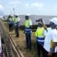 Visitors in safety vests inspect solar panels at the Galgu solar plant in Yendi
