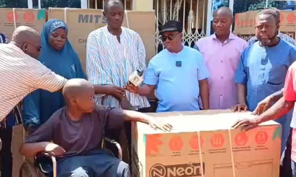 Officials present support items to a beneficiary in Zabzugu