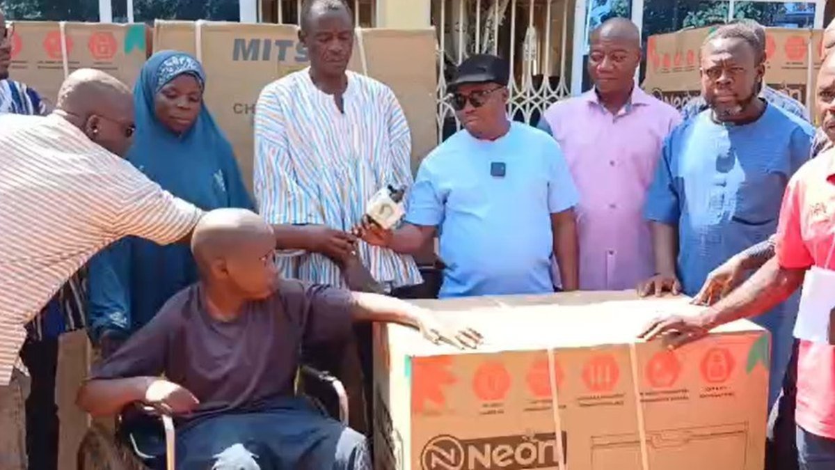 Officials present support items to a beneficiary in Zabzugu